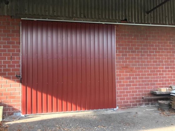 Rotes Blechtor in einer Klinkerwand