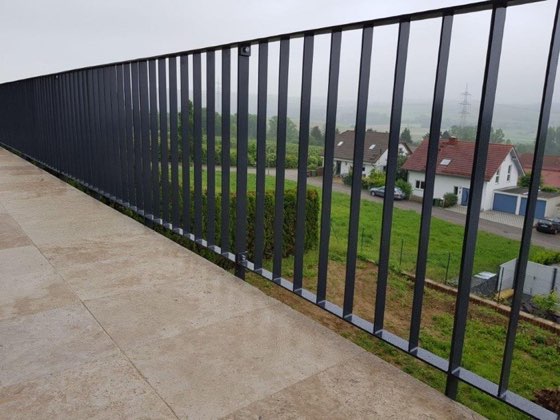 Langes Geländer mit senkrechten Stäben an einer Terrasse