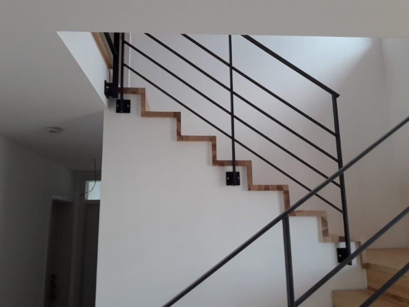 Stahltreppe mit schwarzem Geländer im Treppenhaus