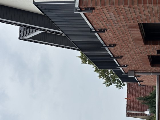 Langes Stahlgeländer auf einer Backsteinmauer